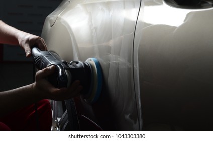 Car detailing - Man holds a polisher in the hand and polishes the car.