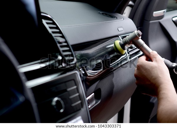 Car detailing - Man holds a polisher in the hand and
polishes the car.