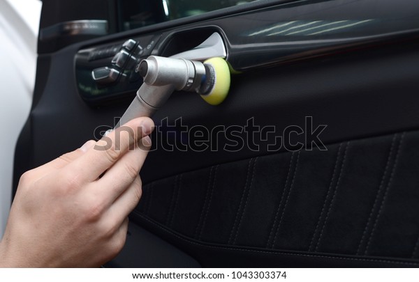 Car detailing - Man holds a polisher in the hand and
polishes the car.