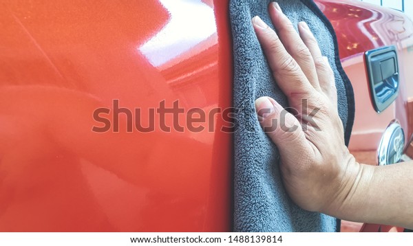 Car Detailing Process. Waxing Car Surface and Wipe\
off with microfiber cloth.