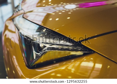 Car detailing series: Clean headlights of yellow sports car.