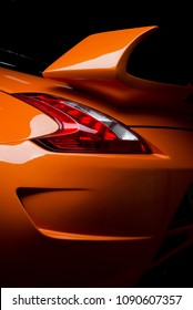 Autodetaillierungsserie: Sauberkeit des hinteren orangefarbenen Sportwagens im Dunkeln