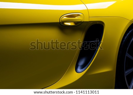 Car detailing series: Closeup of clean yellow sports car’s door