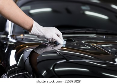 Car detailing series : Closeup of hand coating black car bonnet 