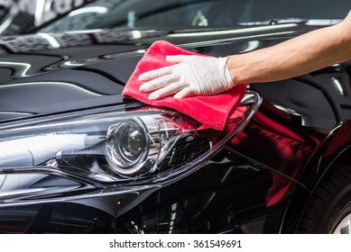 Autodetaillierungsserie: Arbeitswagen, die schwarzes Auto reinigen