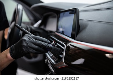 car detailing studio employee carefully cleans the air vents - Shutterstock ID 2193252117