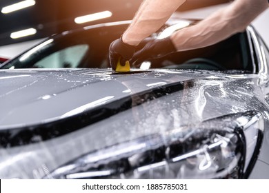 Car Detailing Studio Worker Applying Protective Ppf Foil Film On Car Body