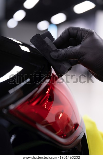 Car\
detailing studio worker applying ceramic\
coating