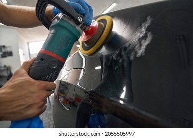 Car detailing studio worker polishing car varnish with electric polisher - Powered by Shutterstock