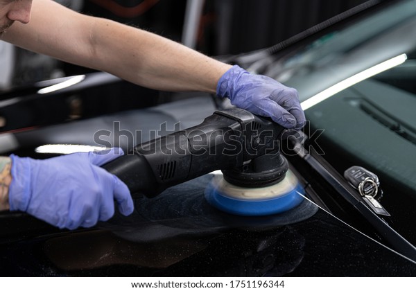Car detailing\
studio worker polishing car\
paint