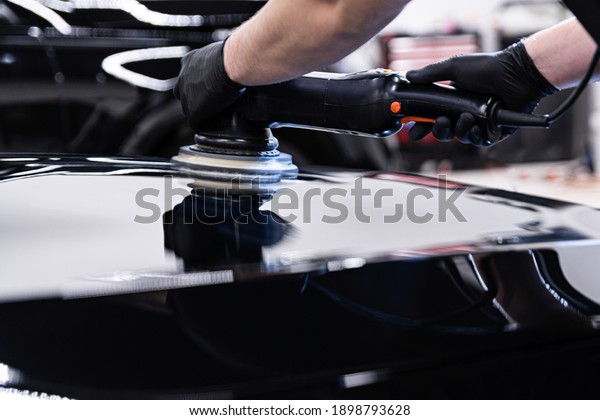 Car detailing\
studio worker polishing car\
paint