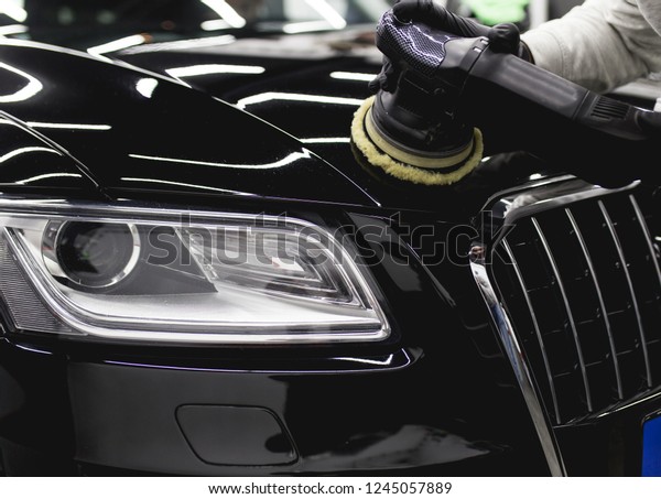 
Car detailing - Worker with orbital polisher in auto
repair shop. 