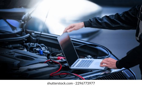 Car diagnostic service close up  computer and modern mechanic in garage. Auto mechanic using computer software for diagnostics engine working and repairing car in a garage. - Powered by Shutterstock