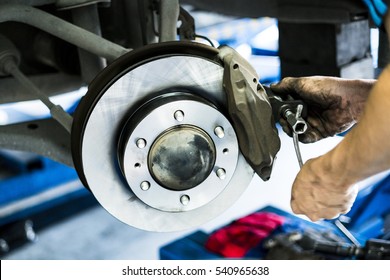 Car disc brake in process of assembly and repair caliper maintenance by mechanic hands with tools in the box as background in natural light. Car Disc break is need annual check and change regularly.