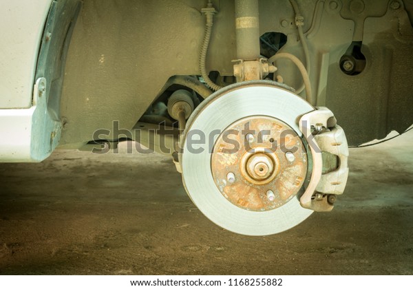 Car disc brake showing rotor and brake caliper,\
Car service.