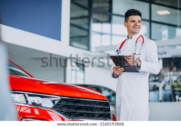 Car doctor with\
stethoscope in a car\
showroom