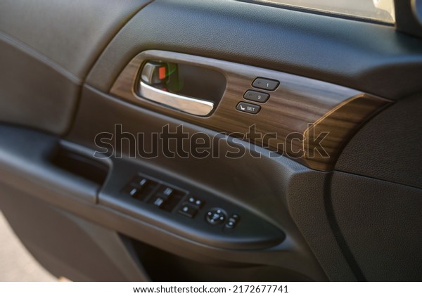 Car door control left panel. Leather new car\
interior. Car inside door chrome handle. Buttons to adjust driver\'s\
seat memory. Lifters control. Blocking the opening and closing of\
windows and doors.