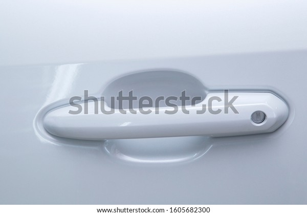 The car\
door handle is white. Exterior of the\
car.