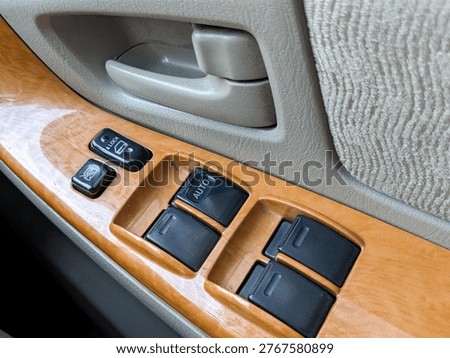 Car Door Interior Control Panel with Power Window Switches Door Lock Button and Wood Grain Trim Detail in Modern Vehicle Cabin for Automotive Component Maintenance and Interior Design