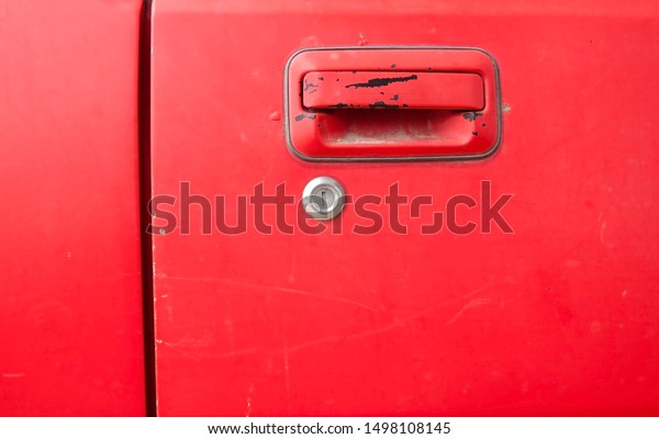 The car door and key lock of\
the old red car are classic cars that are being repaired for\
reuse.