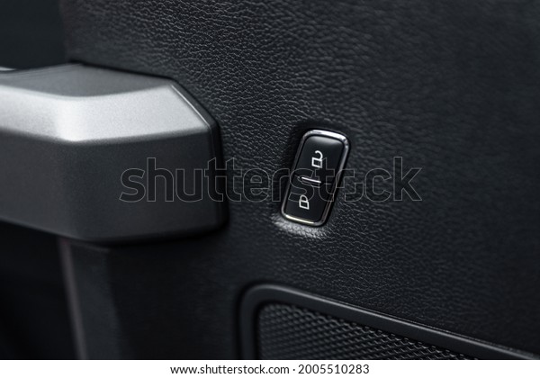 Car door lock unlock\
button close up. Electric central locking button in modern car.\
Selective focus.