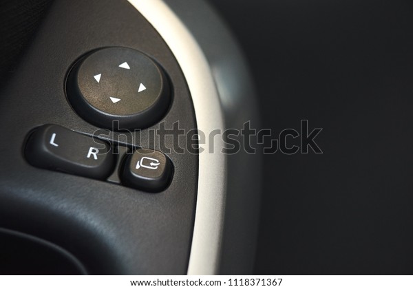 Car door lock, window button and side mirror\
adjuster button on a car.