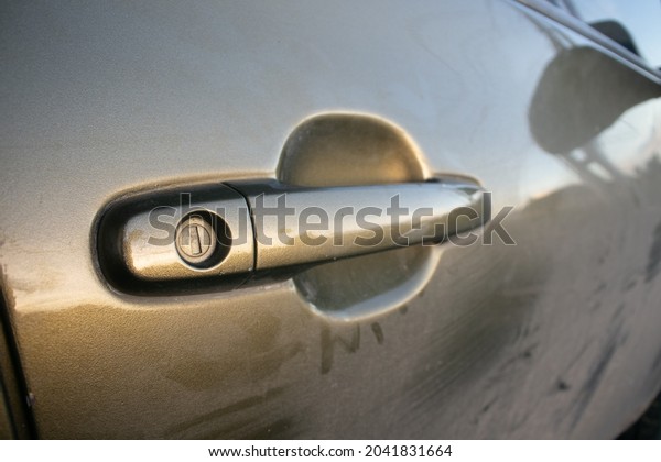 The car door opening handle is brown and there is\
a key holder on the handle