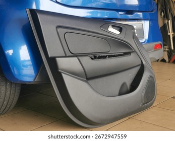 Car door panel opened at a workshop for repair of a faulty power window, exposing inner mechanical components to replace with a new part during service.