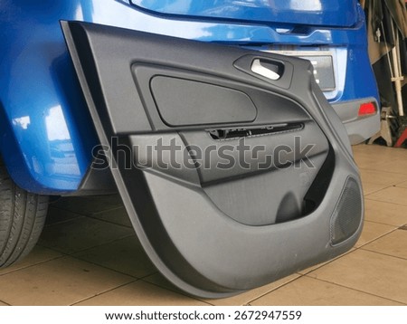 Car door panel opened at a workshop for repair of a faulty power window, exposing inner mechanical components to replace with a new part during service.