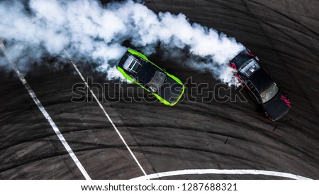 Car drift battle, Two car drifting battle on race track with smoke, Aerial view, Car drifting, Race drift car with lots of smoke from burning tires on speed track.