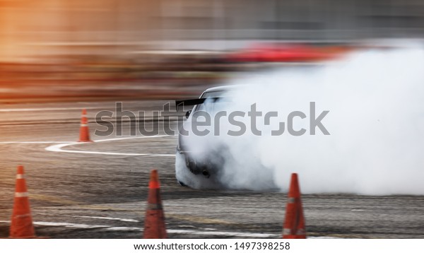 Car drifting,\
Blurred of image diffusion race drift car with lots of smoke from\
burning tires on speed\
track