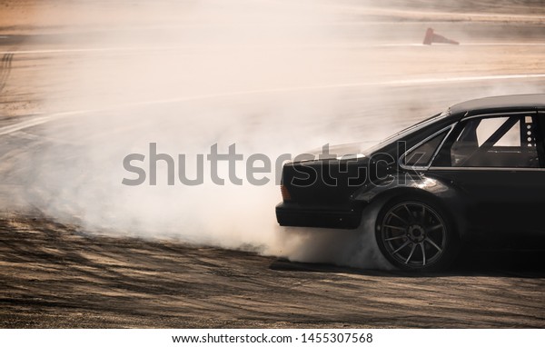 Car drifting, diffusion race drift\
car with lots of smoke from burning tires on speed\
track