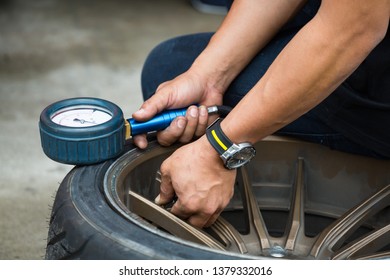 Car drifting, man hand check tire pressure / inflate car tire