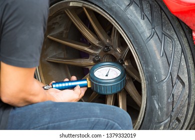 Car drifting, man hand check tire pressure / inflate car tire