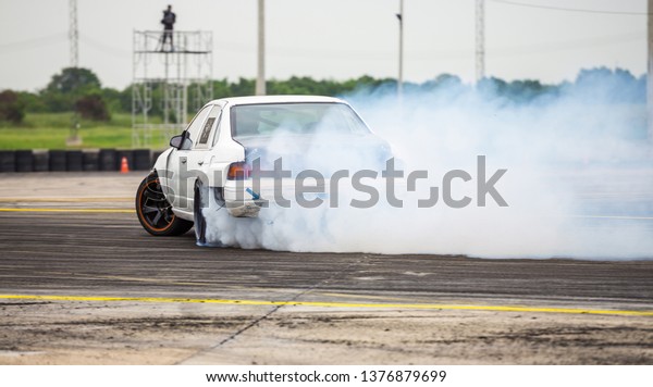 Car drifting, Car wheel\
spinning with smoke coming from wheels, Drag Racing on speed race\
track,