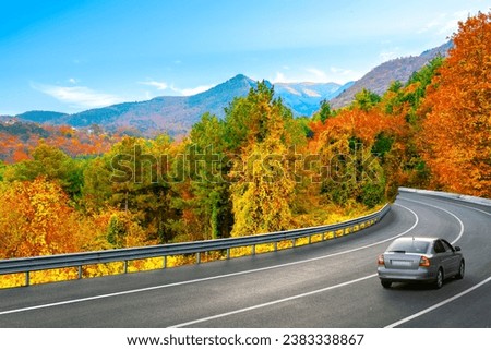 Car in drive for traveling on asphalt road landscape on mountain road in colorful autumn season. Autumn landscape on the highway on beautiful mountain slopes. Nature landscape on the fall forest.
