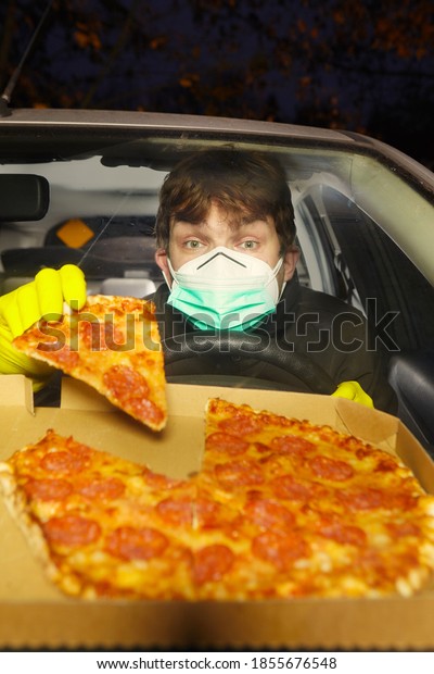 Car\
driver crazy of coronavirus with mask eating\
pizza
