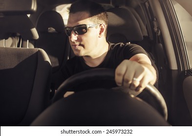 Car Driver Drive His Car In Black Sunglasses. Toned Photo.