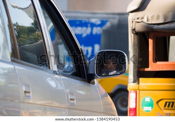 Car Driver Face in\
Side Mirror at Royapuram High Road, North Chennai, Tamil Nadu in\
India on April 20, 2019