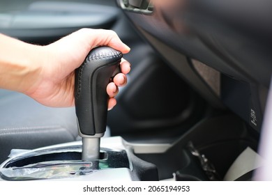 Car driver hand on matic transmission shift lever - Shutterstock ID 2065194953