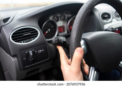 car driver hand push the button and activate windscreen wipers 
