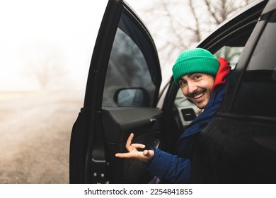 The car driver looks at the camera. Smiling taxi driver. Driver A friendly and friendly man offers a ride. - Powered by Shutterstock