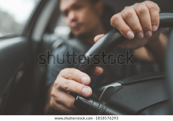 Car driver man close up is\
hands on  Car steering wheel While the turn signal is being turned\
on.