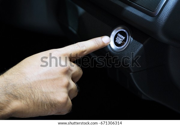 Car driver starting the engine Start engine\
button. Start/stop system.