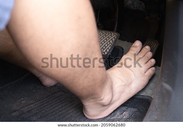 Car driver\
step on the gas pedal with bare\
feet.