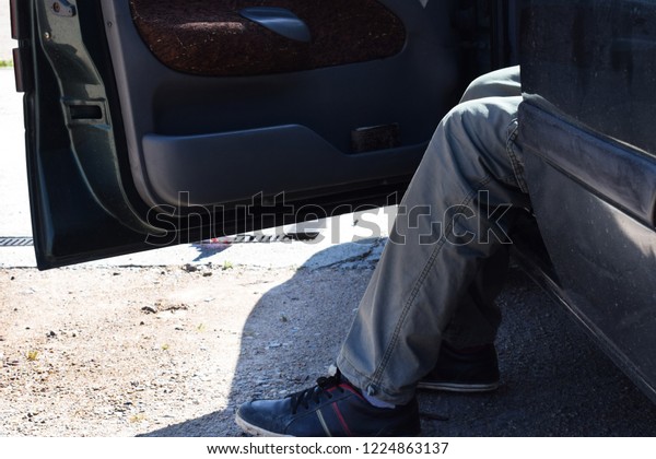the\
car driver is tired and rests, with the car door\
open