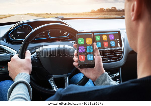 Car driver use\
smart phone with smart car app and use connection with car\
infotainment system while\
driving.