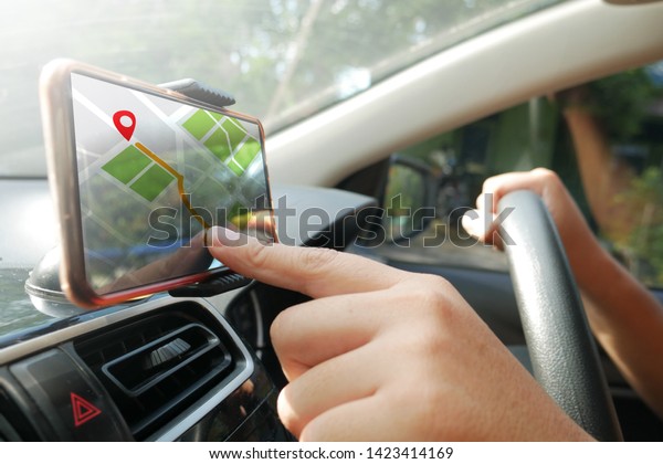Car driver using smart phone with GPS\
map navigation while driving, car sharing app\
concept