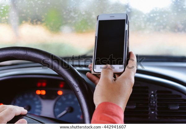 Car driver using smart phone, closeup on hand,\
mockup screen background