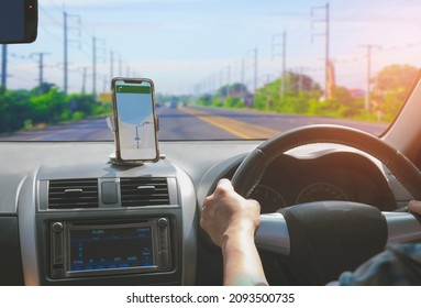 Car driver using smartphone with GPS map navigation application while driving on highway, view from inside car - Shutterstock ID 2093500735